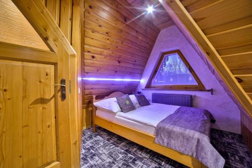 a bedroom with a bed in a wooden cabin at Śwarna Wynajem Pokoi in Zakopane