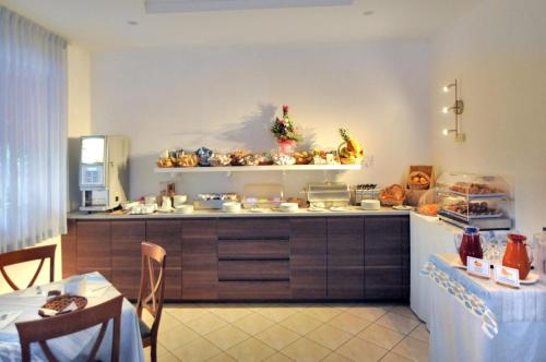 a kitchen with a counter and a table in a room at Hotel Rex in Caorle