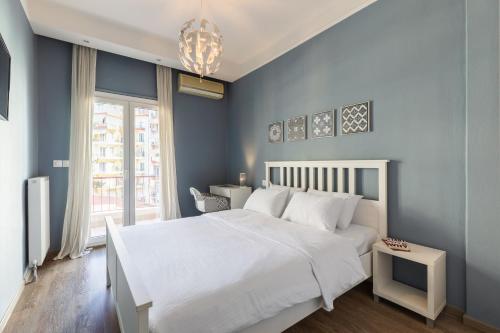 - une chambre avec un lit blanc et un mur bleu dans l'établissement Danae by halu! 2-bedroom apartment in the center, à Thessalonique