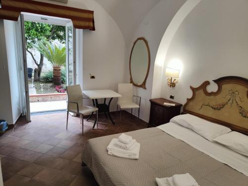 a hotel room with a bed and a table with chairs at Androsa Apartments in Amalfi