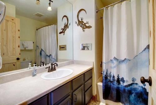 baño con lavabo y cortina de ducha en New Listing - Slopeside condo with Private Hot Tub en Granby