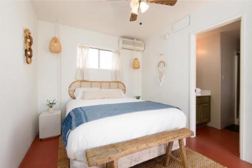 um quarto com uma cama e um banco de madeira em Renovated Lodge - Room 2 with pool access em Joshua Tree