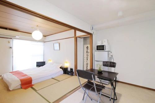 広島市にあるDai3Himawari by b hotel - Best location ! 1 min walk to Peace Park Dome -701のベッドとテーブルと机のある寝室