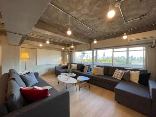 a living room with couches and a table at b hotel Dai3Himawari - 30 sec to PeacePark!! HUGE comfort house Up to 10p in Hiroshima
