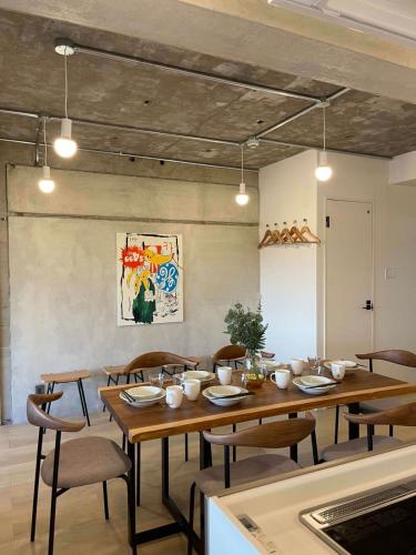 a dining room with a wooden table and chairs at b hotel Dai3Himawari - 30 sec to PeacePark!! HUGE comfort house Up to 10p in Hiroshima