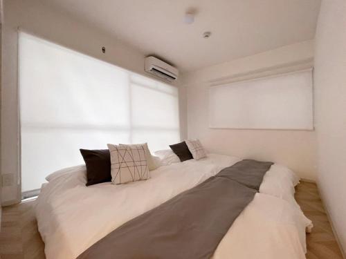 a large bed in a room with a large window at b hotel Dai3Himawari - 30 sec to PeacePark!! HUGE comfort house Up to 10p in Hiroshima