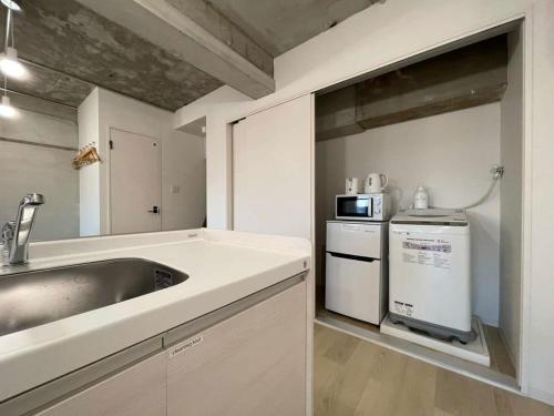 a white kitchen with a sink and a dishwasher at bHOTEL Dai3Himawari - 30 sec to PeacePark!! HUGE comfort house Up to 10p in Hiroshima
