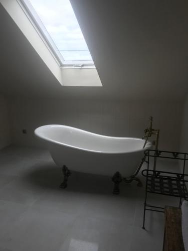 a large white bath tub in a bathroom with a skylight at Willa w Piszu in Pisz