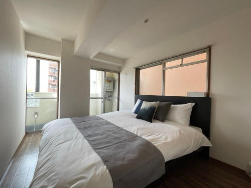 広島市にあるbHOTEL Dai3Himawari - 2BR good for 6PPL overlooking Peace Park with WIFI!のベッドルーム1室(大きなベッド1台、大きな窓付)