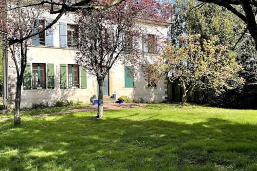 a house with trees in front of a yard at Le Manoir Mermoz : Appartement T2 tout équipé in Rennes