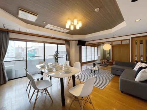 a living room with a white table and chairs at bHOTEL M bld - Beautiful, spacious apartment next to Peace Park in Hiroshima