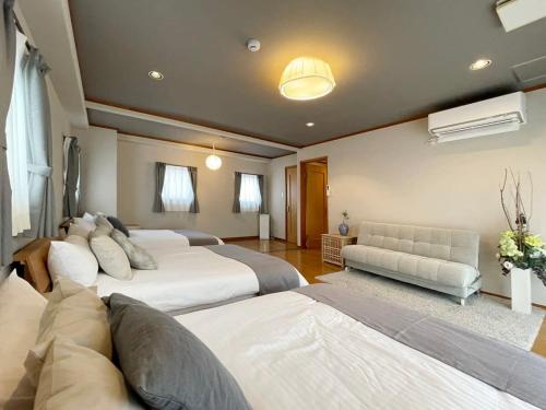 a large bedroom with two beds and a couch at bHOTEL M bld - Beautiful, spacious apartment next to Peace Park in Hiroshima