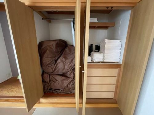 a room with a closet with a bed and towels at bHOTEL M bld - Beautiful, spacious apartment next to Peace Park in Hiroshima