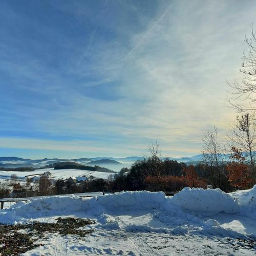 a pile of snow on the ground with mountains in the background at Ałabajka in Wleń