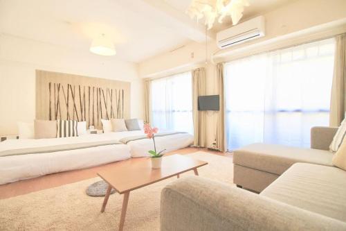 a living room with two white couches and a table at Earls Court by b hotel - Spacious & Relaxing just 4 blocks to Peace Park in Hiroshima