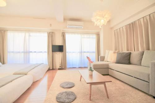 a living room with a couch and a table at Earls Court by b hotel - Spacious & Relaxing just 4 blocks to Peace Park in Hiroshima