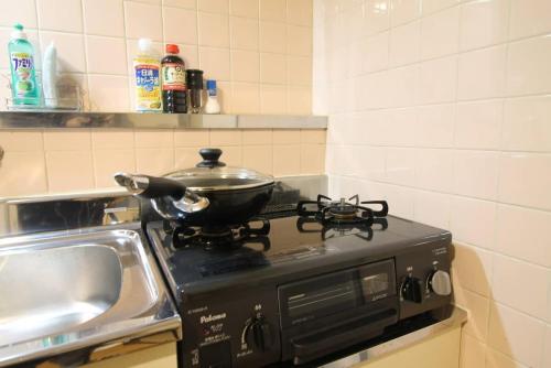 a pot on top of a stove in a kitchen at Earls Court - Capacious & Relaxing just 4 blocks to Peace Park in Hiroshima