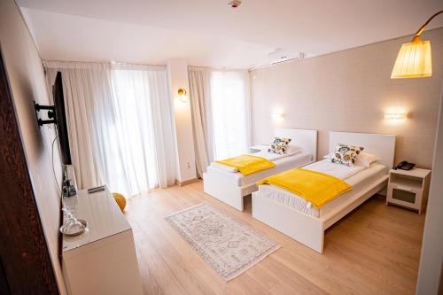 1 dormitorio con 2 camas y TV. en Hotel Senator, en Timisoara