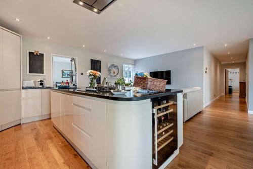 a kitchen with a counter with wine bottles at Oakwood Bungalow Christchurch Sleeps 8 in Iford