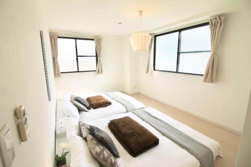 two beds in a room with two windows at Luxes - 10 min Hiroshima Station & 2BR Up to 10p in Hiroshima