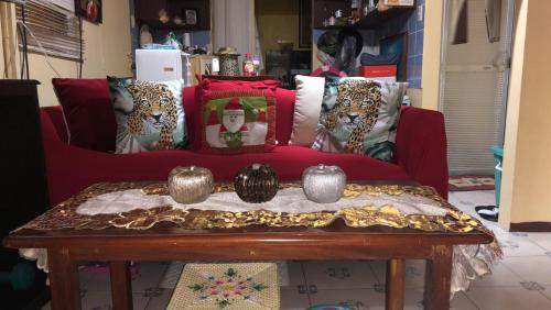 uma sala de estar com um sofá vermelho com almofadas em Crystal Aire em General Trias