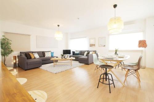 a living room with a couch and a table at Marumasa by b hotel - Large 2BR Apt 10PPL near Peace Park 301 in Hiroshima