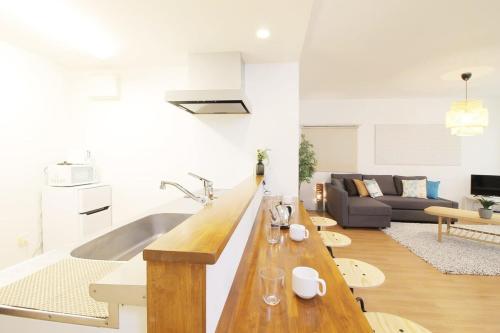 a kitchen and living room with a long wooden table at Marumasa by b hotel - Large 2BR Apt 10PPL near Peace Park 301 in Hiroshima