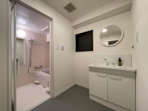W łazience znajduje się umywalka, toaleta i lustro. w obiekcie bHOTEL M's lea - Modern Spacious Apartment Beside Peace Park 10 ppl w mieście Hiroszima