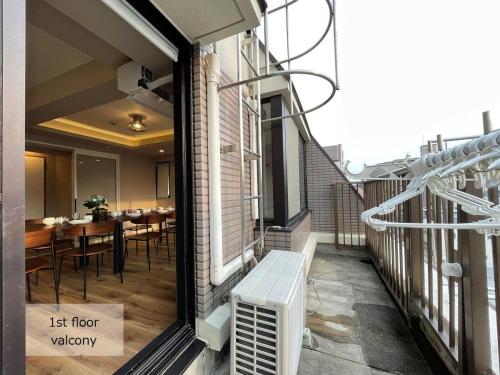 a balcony with a table and chairs on a building at bHOTEL M's lea - Spacious 2 level apartment 4BR for 16 PPL in Hiroshima