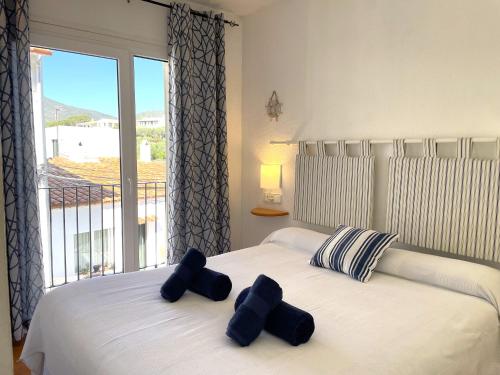 1 dormitorio con 1 cama con 2 almohadas y ventana en CREUS - Apartment in the center of town, en Cadaqués
