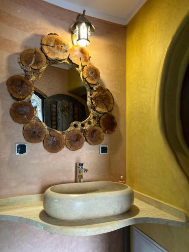a bathroom with a round sink and a mirror at Grand Canyon Lodge Dades in Aït Idaïr