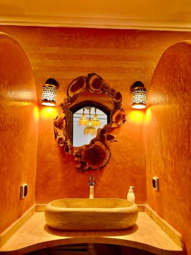 a bathroom with a sink and a mirror at Grand Canyon Lodge Dades in Aït Idaïr