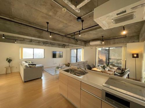 a kitchen and living room with a couch and a sink at b hotel M's lea - Spacious Family apartment next to Peace Park in Hiroshima