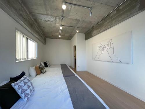 Habitación con cama y pintura en la pared en bHOTEL M's lea - Spacious Family apartment next to Peace Park en Hiroshima