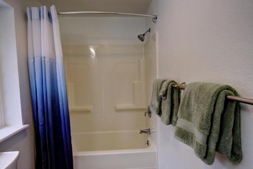W łazience znajduje się prysznic i zielone ręczniki. w obiekcie Green Valley Getaway - 2br Family Friendly Home w mieście Mendenhaven