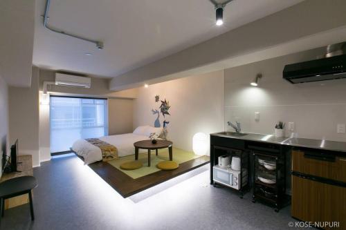 a bedroom with a bed and a table and a sink at bHOTEL Origaminn 303 - 5 mins PeacePark in Hiroshima