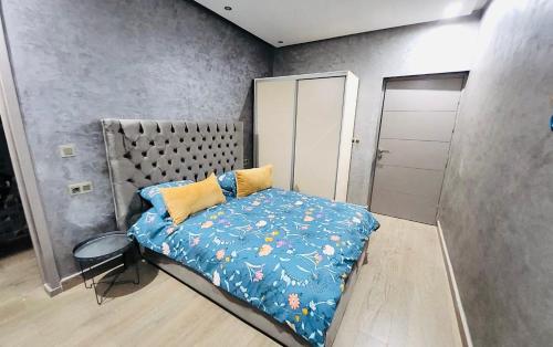 1 dormitorio con 1 cama con edredón azul en Villa Naouma, en Marrakech