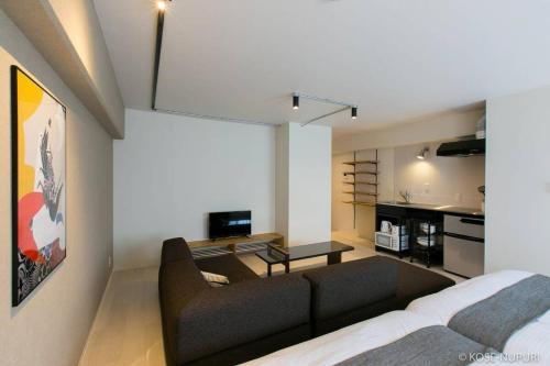 a living room with a couch and a kitchen at bHOTEL Origaminn 501 - 5 mins PeacePark in Hiroshima