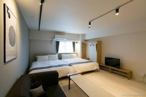 um quarto com uma cama grande e um sofá em bHOTEL Origaminn 502 - 5 mins PeacePark em Hiroshima
