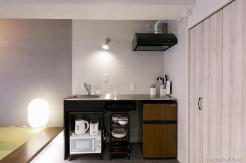 uma cozinha com um lavatório e uma bancada em bHOTEL Origaminn 403 - 5 mins PeacePark em Hiroshima
