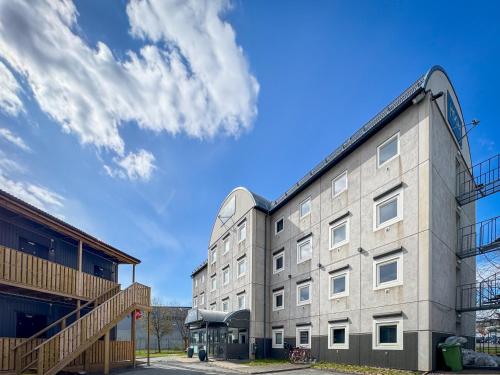 un edificio de apartamentos con un cielo azul en el fondo en HOOM Home & Hotel Jönköping, en Jönköping