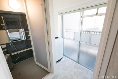 a bathroom with a shower and a glass door at bHOTEL Origaminn 601 - 5 mins PeacePark in Hiroshima