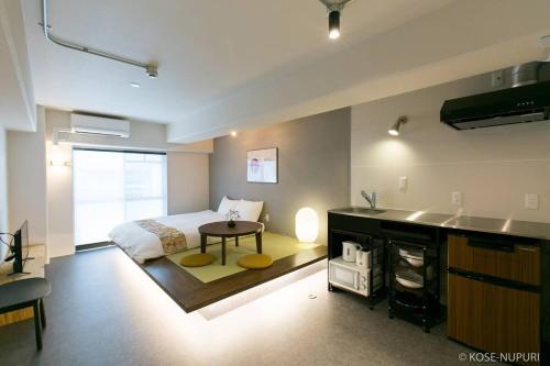 a bedroom with a bed and a kitchen with a table at bHOTEL Origaminn 603 - 5 mins PeacePark in Hiroshima