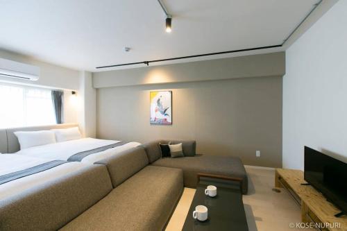a bedroom with a large bed and a couch at bHOTEL Origaminn 701 - 5 mins PeacePark in Hiroshima