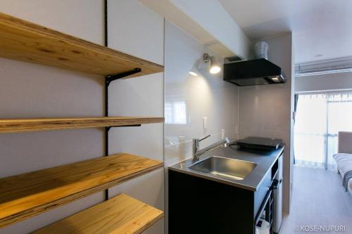 a small kitchen with a sink and a counter top at bHOTEL Origaminn 701 - 5 mins PeacePark in Hiroshima