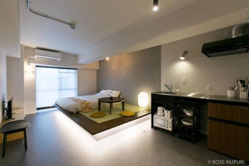 1 dormitorio con 1 cama y cocina con mesa en bHOTEL Origaminn 703 - 5 mins PeacePark, en Hiroshima