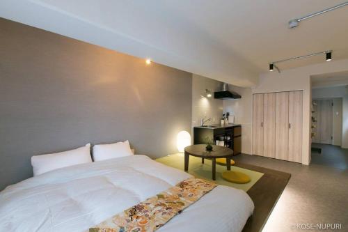 ein Schlafzimmer mit einem großen Bett und einem Tisch in der Unterkunft bHOTEL Origaminn 703 - 5 mins PeacePark in Hiroshima