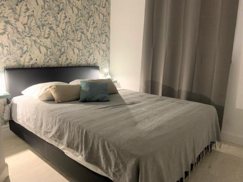 a bedroom with a large bed with a gray headboard at 18 - LE VACOA - TI VACOA in Saint-Paul