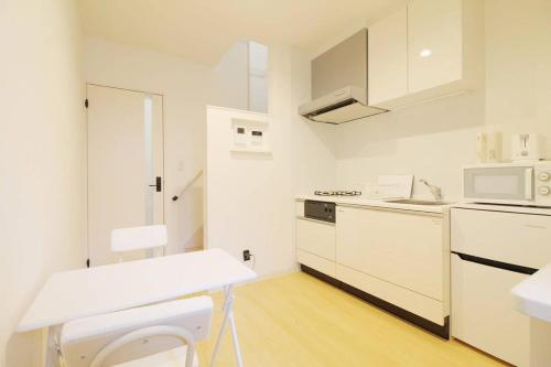 a white kitchen with a sink and a microwave at bHOTEL Ball Park - 2mins walk Baseball 5mins walk Hiroshima Sta 4ppl in Hiroshima