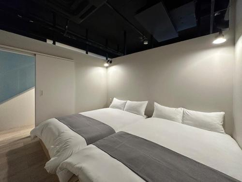a bedroom with a large white bed in a room at bHOTEL New Small Hotel - Hondori shopping arcade in Hiroshima